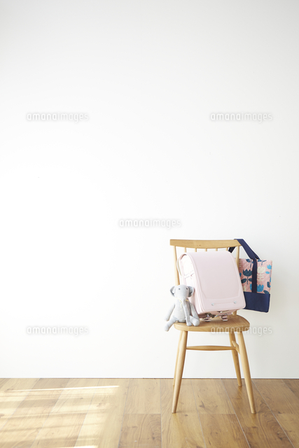 壁の前の椅子とその上のランドセル の写真素材 イラスト素材 アマナイメージズ
