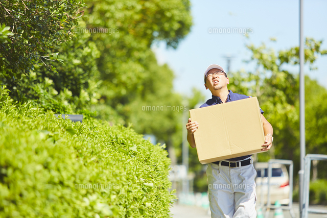 炎天下で辛そうに荷物を運ぶ作業員 の写真素材 イラスト素材 アマナイメージズ