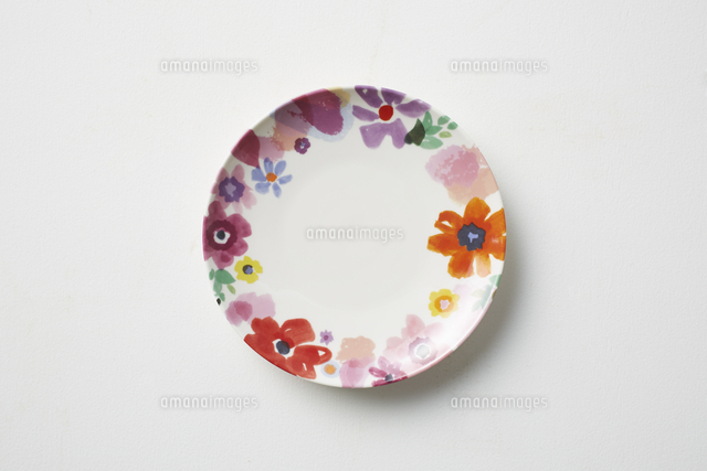 暖色系の花の絵が描かれた皿 の写真素材 イラスト素材 アマナイメージズ