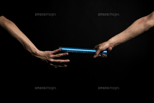 黒い背景でバトンパスをする男性の陸上選手 の写真素材 イラスト素材 アマナイメージズ