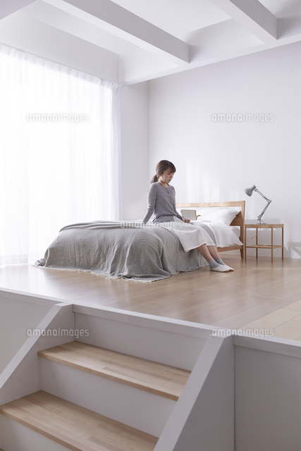 ステップフロアのシンプルなベッドルームでベッドに座る女性 の写真素材 イラスト素材 アマナイメージズ ステップフロアのシンプルなベッドルームでベッドに座る女性 の写真素材 イラスト素材 アマナイメージズ