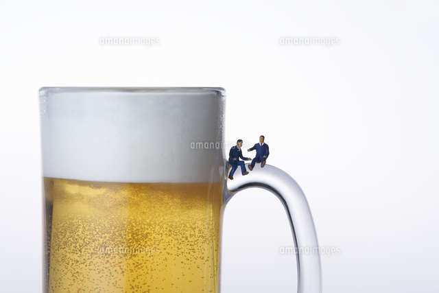 ビールジョッキの取っ手に座るスーツ姿のミニチュア人形 の写真素材 イラスト素材 アマナイメージズ