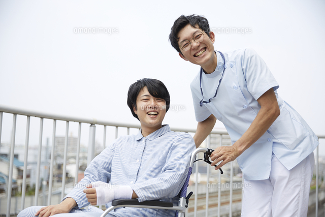 笑顔でカメラ目線の看護師と車椅子の患者 の写真素材 イラスト素材 アマナイメージズ