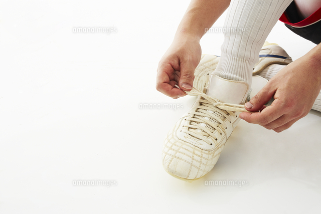 スパイクの紐を結ぶサッカー選手 の写真素材 イラスト素材 アマナイメージズ