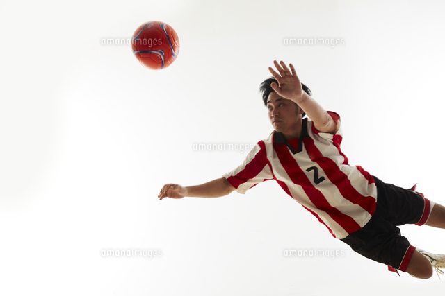 飛び込んでヘディングをする瞬間のサッカー選手 の写真素材 イラスト素材 アマナイメージズ