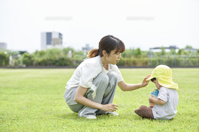 芝生で座って子供にお茶を飲ませる女性の保育士 の写真素材 イラスト素材 アマナイメージズ 芝生で座って子供にお茶を飲ませる女性の保育士 の写真素材 イラスト素材 アマナイメージズ