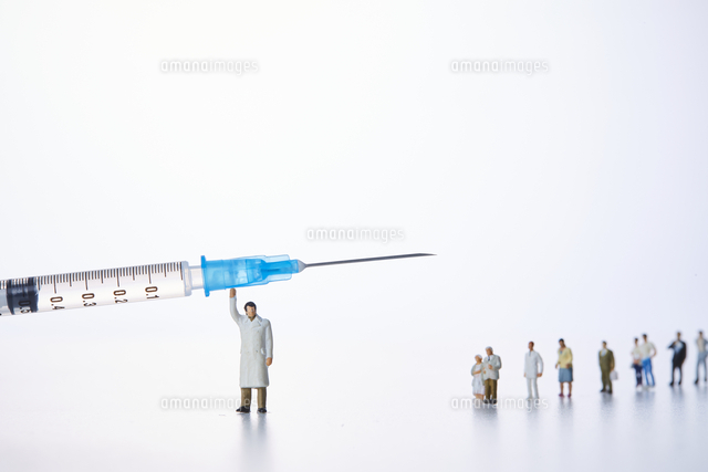 注射器を支えている医者のミニチュア人形 の写真素材 イラスト素材 アマナイメージズ