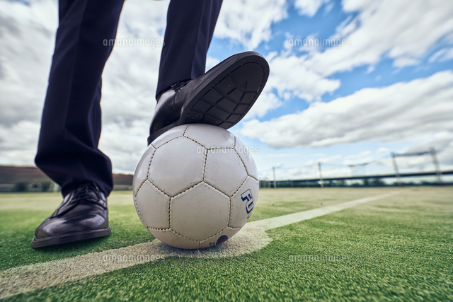 サッカーボールを足で押さえるサラリーマンの足元 の写真素材 イラスト素材 アマナイメージズ