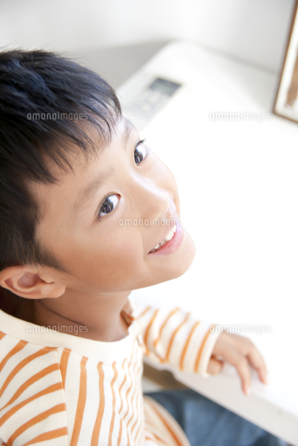 座りながら見上げる男の子 の写真素材 イラスト素材 アマナイメージズ