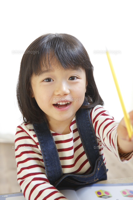 ペンを持つ笑顔の女の子 の写真素材 イラスト素材 アマナイメージズ