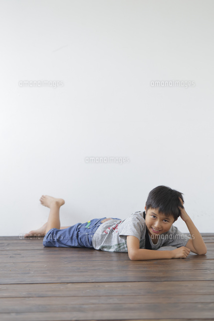 床にうつ伏せになる少年[10186008080]の写真素材・イラスト素材 