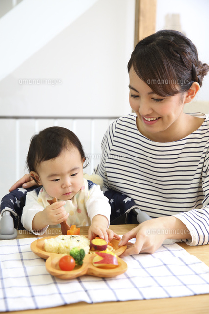 赤ちゃんにごはんを食べさせる若い母親 の写真素材 イラスト素材 アマナイメージズ