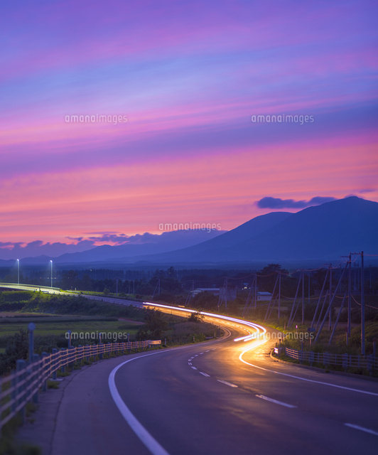 北海道 十勝平野 点景 夕焼けに続く道[10190001194]の写真・イラスト