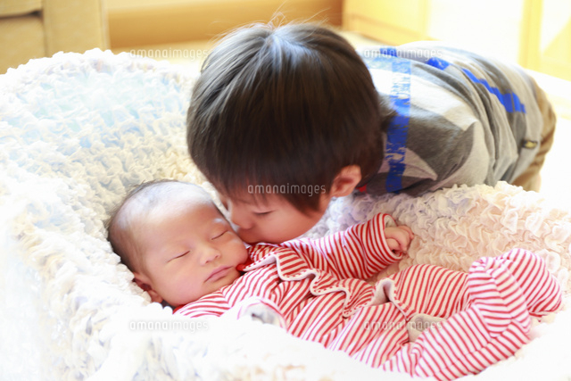 誕生三週間目の眠っている赤ちゃんにキスをする男の子 の写真素材 イラスト素材 アマナイメージズ