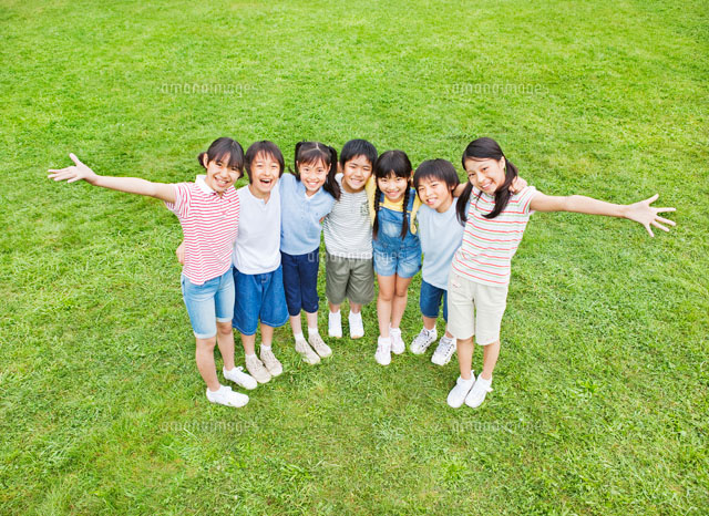 芝生で肩を組む7人の小学生の男の子と女の子 俯瞰 の写真素材 イラスト素材 アマナイメージズ