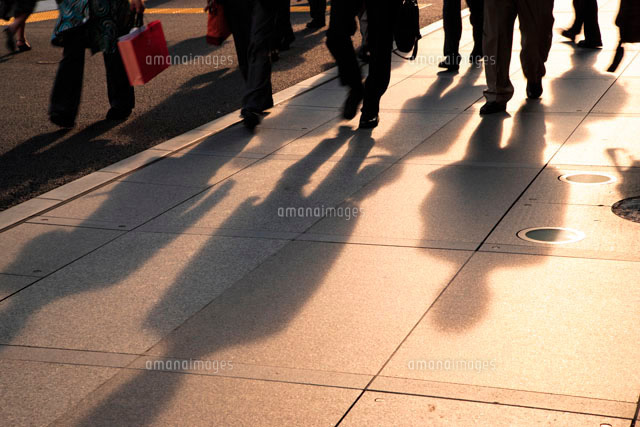 夕方の歩道に映るビジネスマンたちの影 の写真素材 イラスト素材 アマナイメージズ