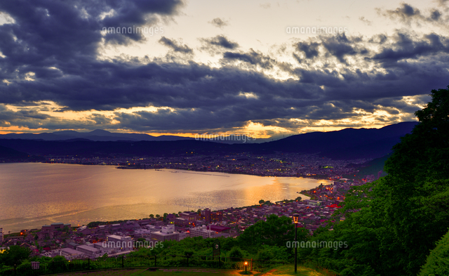 立石公園より夕焼けに染まる諏訪湖と明かりが灯る湖畔の街並み