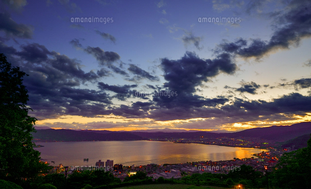 立石公園より夕焼けに染まる諏訪湖と明かりが灯る湖畔の街並み