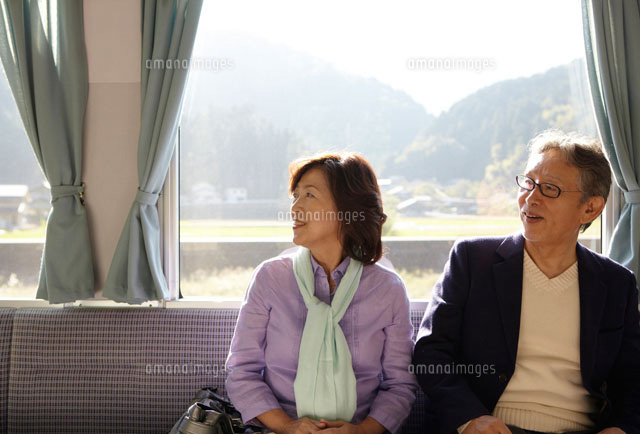 山間の田舎町を電車で旅行するシニア夫婦 の写真素材 イラスト素材 アマナイメージズ