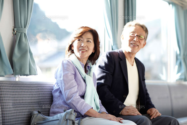 山間の田舎町を電車で旅行するシニア夫婦 の写真素材 イラスト素材 アマナイメージズ