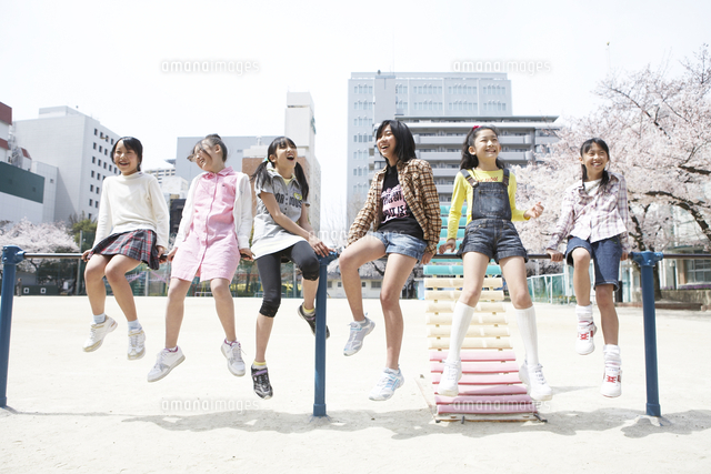 鉄棒で遊ぶ小学生の女の子 の写真素材 イラスト素材 アマナイメージズ