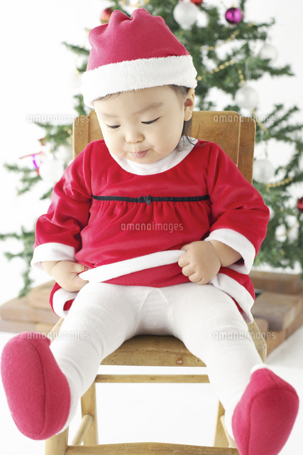 クリスマスツリーとサンタクロースの衣装を着た赤ちゃん の写真素材 イラスト素材 アマナイメージズ
