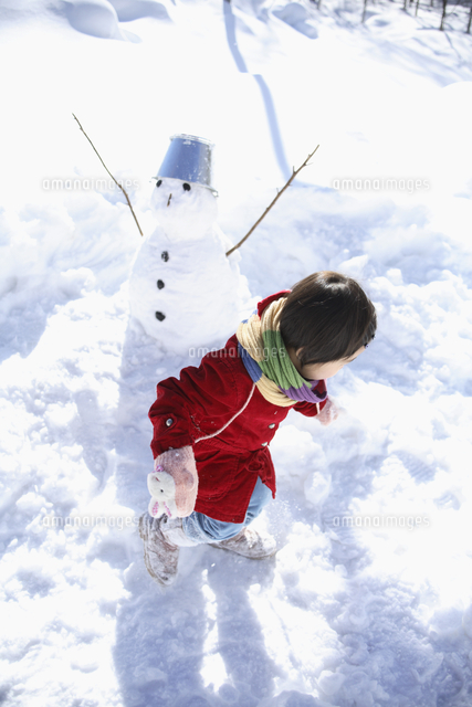 雪山で遊ぶ女の子と雪ダルマ の写真素材 イラスト素材 アマナイメージズ