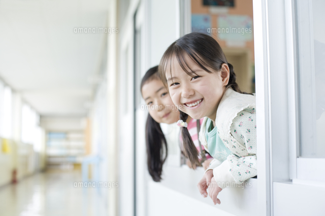 教室の窓から顔を出している小学生の女の子 の写真素材 イラスト素材 アマナイメージズ