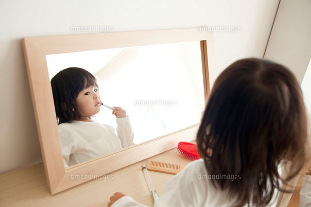 鏡の前でお化粧をする女の子 の写真素材 イラスト素材 アマナイメージズ