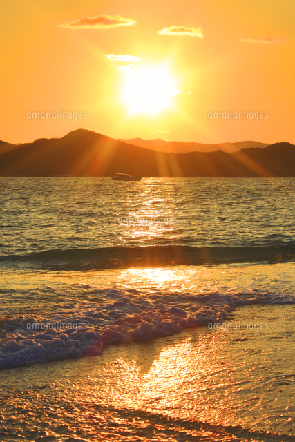 打ち寄せる波と安室島と朝日と漁船 の写真素材 イラスト素材 アマナイメージズ