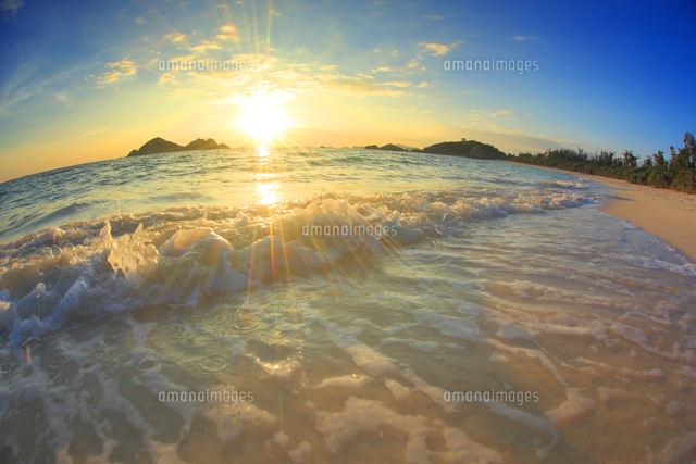 阿波連ビーチの渚に打ち寄せる波と夕日 魚眼 の写真素材 イラスト素材 アマナイメージズ