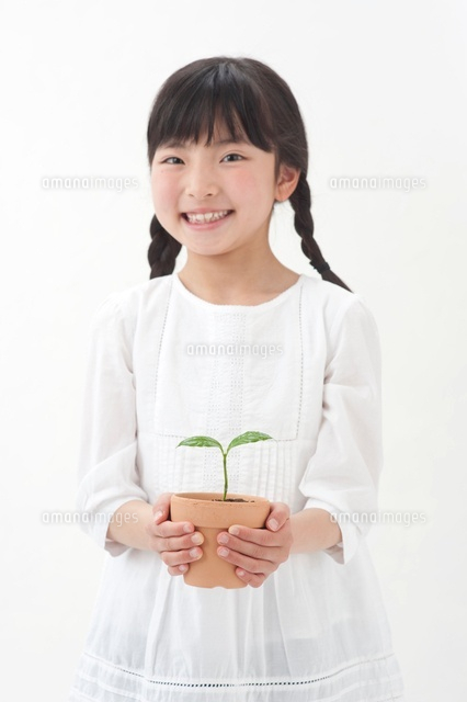 双葉の鉢植えを持つ女の子 の写真素材 イラスト素材 アマナイメージズ