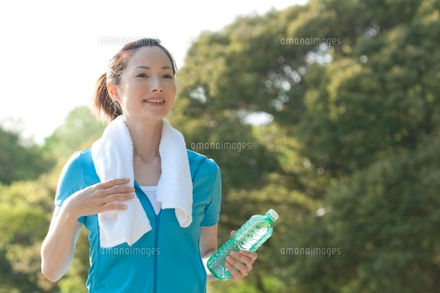 公園でタオルを肩にかけるスポーツウェアの２０代女性 の写真素材 イラスト素材 アマナイメージズ