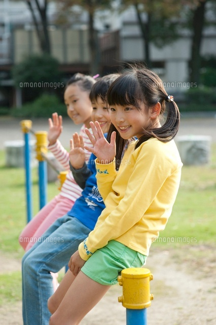 公園で鉄棒に腰かけて手を振る子供男女3人 の写真素材 イラスト素材 アマナイメージズ