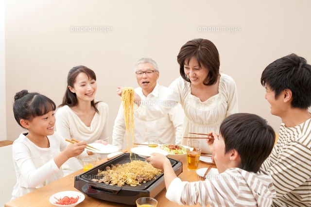 ホットプレートで焼そばをする3世代家族 の写真素材 イラスト素材 アマナイメージズ