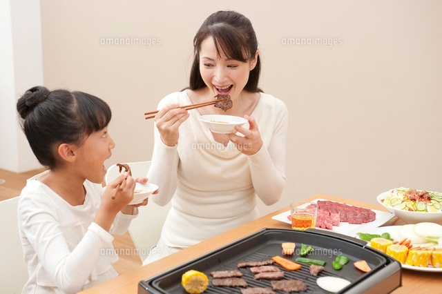 焼肉を食べる母と女の子 の写真素材 イラスト素材 アマナイメージズ
