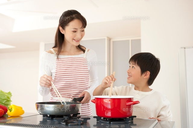 フライパンを持って料理する女性と男の子 の写真素材 イラスト素材 アマナイメージズ