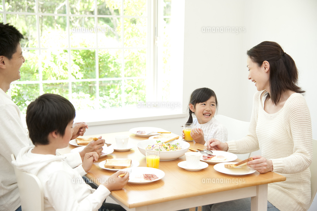 パンの朝食を食べる四人家族 の写真素材 イラスト素材 アマナイメージズ