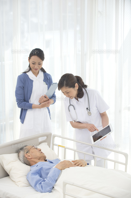 病院ベッドの老人を診察する女医と看護師 の写真素材 イラスト素材 アマナイメージズ
