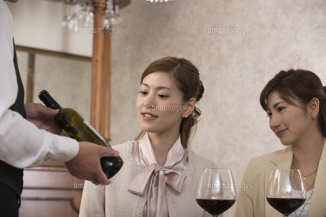 ソムリエにワインの銘柄を聞く女性２人 の写真素材 イラスト素材 アマナイメージズ