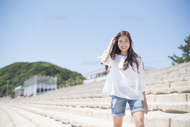 海の堤防を歩く女性 の写真素材 イラスト素材 アマナイメージズ