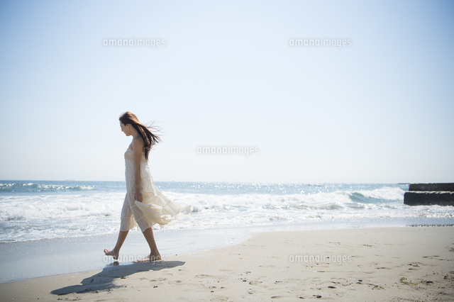 海の砂浜を素足で散歩する女性 の写真素材 イラスト素材 アマナイメージズ
