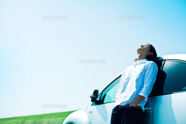 自動車にもたれて空を見上げる男性 の写真素材 イラスト素材 アマナイメージズ