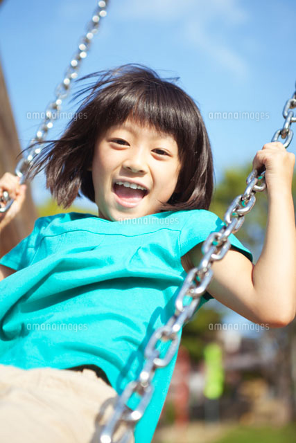 ブランコで遊ぶ笑顔の女の子 の写真素材 イラスト素材 アマナイメージズ