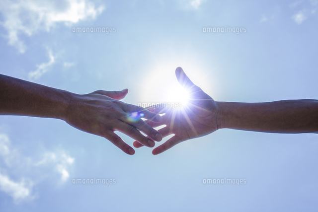 青空と太陽と伸ばした2人の手 の写真素材 イラスト素材 アマナイメージズ