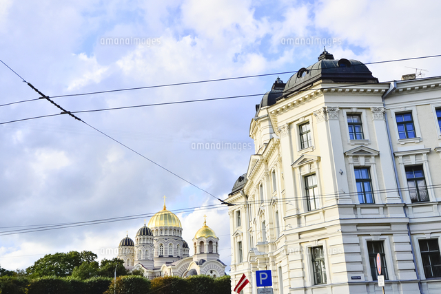 ラトビア 首都リガにある救世主生誕大聖堂とラトビアの国旗 が飾られた建物 大聖堂はロシア帝国時代の19世 の写真素材 イラスト素材 アマナイメージズ
