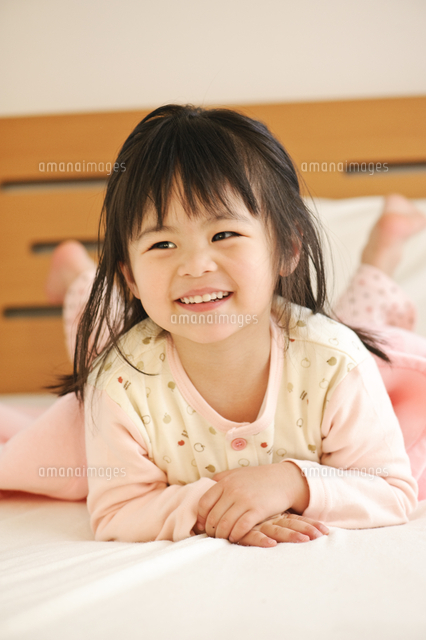 ベッドで遊ぶ笑顔の子ども の写真素材 イラスト素材 アマナイメージズ