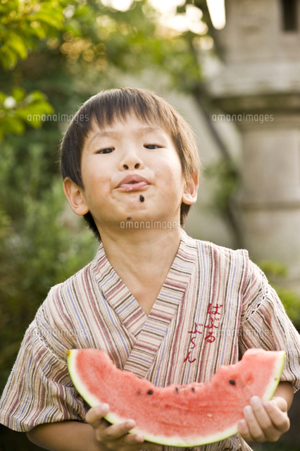スイカの種を飛ばす男の子 の写真素材 イラスト素材 アマナイメージズ