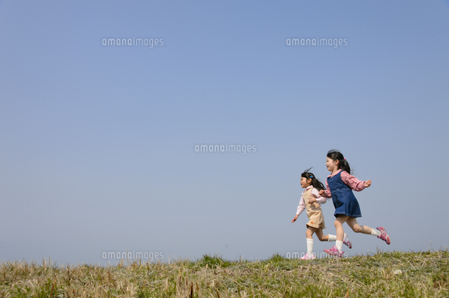 土手の上を走る子ども の写真素材 イラスト素材 アマナイメージズ