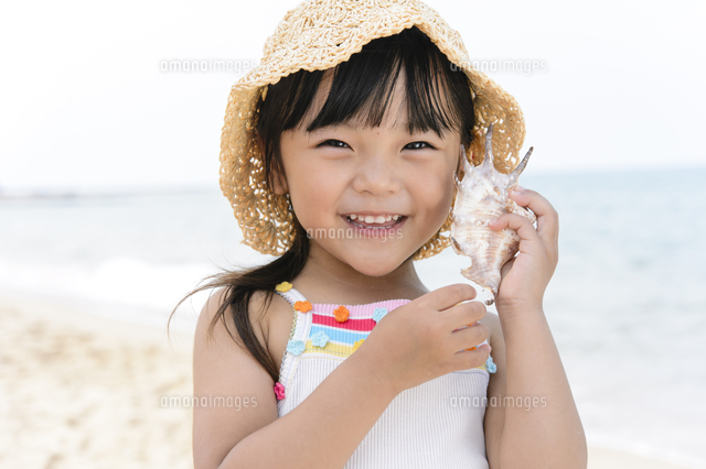 海で貝殻を持つ女の子 の写真素材 イラスト素材 アマナイメージズ
